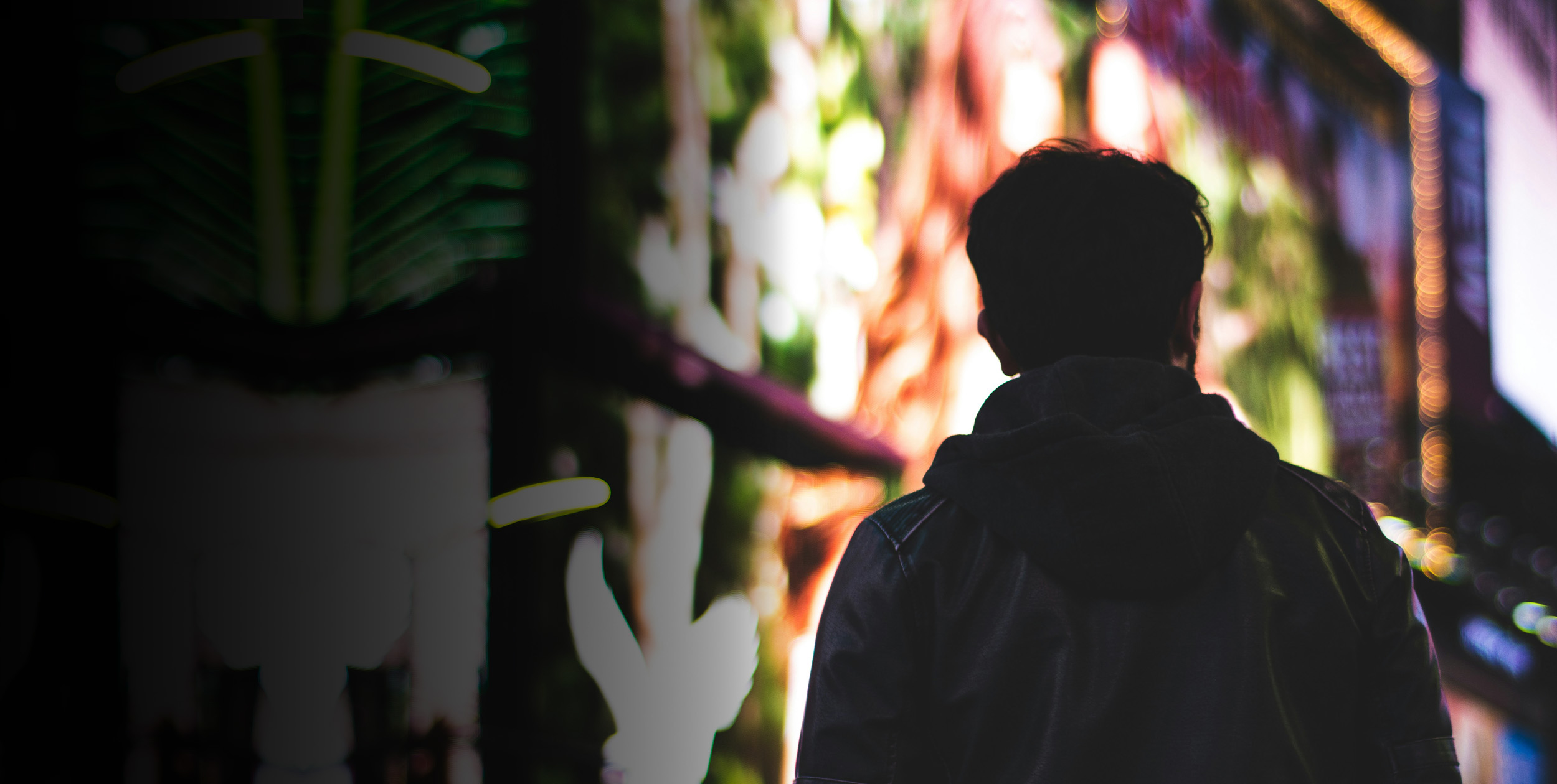 Man med ryggen mot kameran i stadsmiljö.