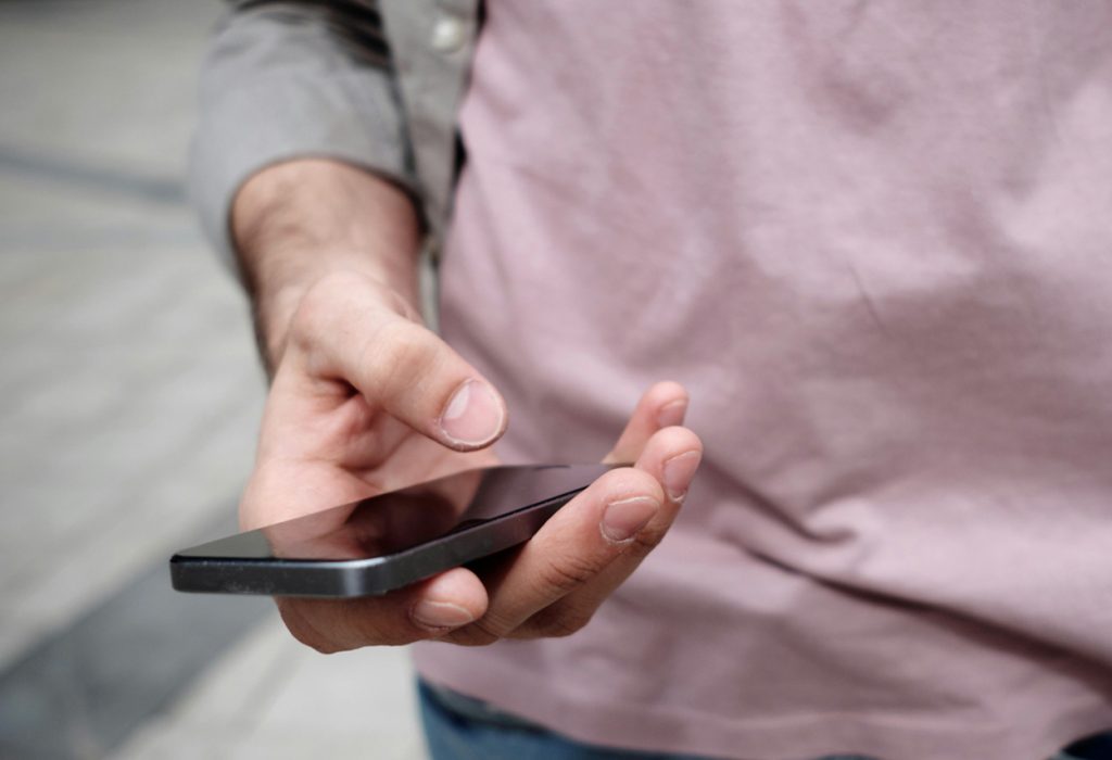 Man håller i mobiltelefon. Närbild.