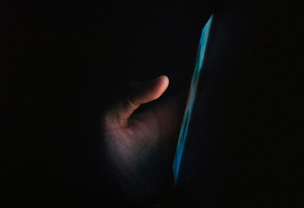 Hand trycker på en mobiltelefonskärm.