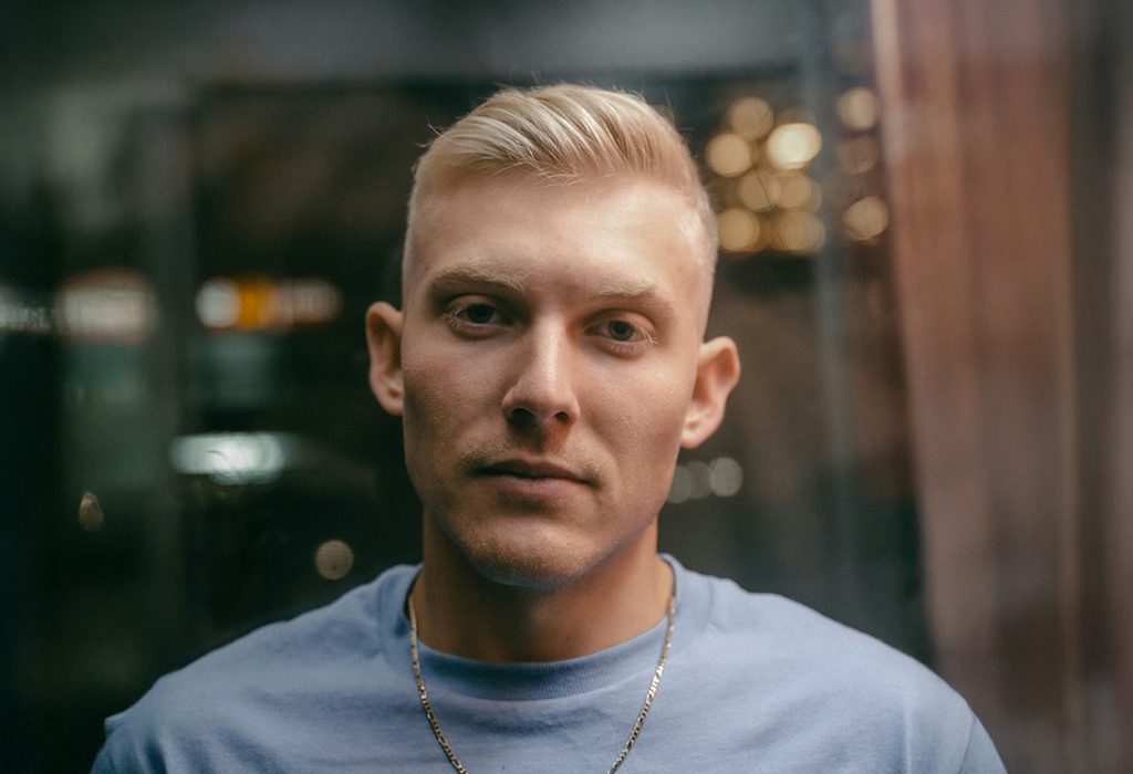 Ung man med allvarlig min tittar rakt mot dig.