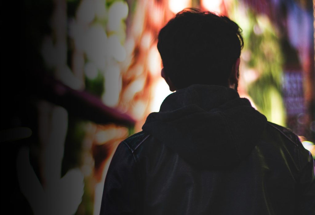 Man fotograferad bakifrån i stadsmiljö.